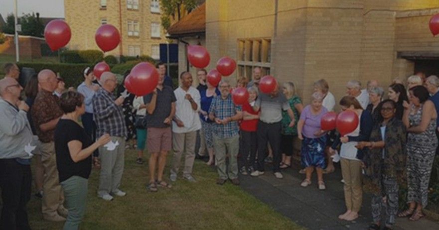 The church congregation outside with balloons.